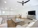 Cozy loft area with neutral décor, railing, and media console at 119 Creek Se Dr, Port Charlotte, FL 33952