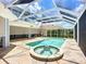 A screened-in pool and hot tub offer privacy and outdoor enjoyment at 119 Creek Se Dr, Port Charlotte, FL 33952