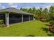 Expansive backyard with lush green lawn, screened lanai with a hot tub, and mature trees at 12300 El Prado Dr, Punta Gorda, FL 33955