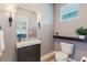 Stylish powder room featuring a modern vanity, sleek fixtures, wood-look tile flooring, and a toilet at 12300 El Prado Dr, Punta Gorda, FL 33955