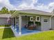 Inviting porch featuring a hanging swing, columns, and an American flag, offering a cozy outdoor space at 12300 El Prado Dr, Punta Gorda, FL 33955