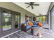 The screened lanai features comfortable wicker seating with blue cushions and orange throw pillows at 12300 El Prado Dr, Punta Gorda, FL 33955