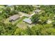 An aerial view highlights a home with generous yard space, surrounded by mature trees and lush landscaping at 1242 Orlando Blvd, Port Charlotte, FL 33952