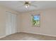 This bedroom features a ceiling fan, closet, and window for natural light at 1242 Orlando Blvd, Port Charlotte, FL 33952