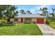 Charming single-story home with an attached garage and a well-maintained lawn at 1242 Orlando Blvd, Port Charlotte, FL 33952