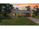 Charming single-story home with a well-maintained lawn and a cozy curb appeal at sunset at 1242 Orlando Blvd, Port Charlotte, FL 33952