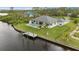 A beautiful aerial view shows the home, dock, in ground pool, and yard with lush grass along the canal at 12581 Eisenhower Dr, Port Charlotte, FL 33953