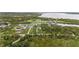 An aerial view highlighting the property's borders nestled among lush trees, near a winding canal, and overlooking the river beyond at 12581 Eisenhower Dr, Port Charlotte, FL 33953