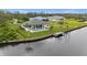Aerial view of waterfront home with a pool and a dock, surrounded by lush greenery in a desirable neighborhood at 12581 Eisenhower Dr, Port Charlotte, FL 33953