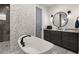 Chic bathroom with a soaking tub, gray walls, walk-in shower and dark wood vanity at 12581 Eisenhower Dr, Port Charlotte, FL 33953