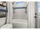 Modern bathroom with a white tub, blue tile accent, and natural light from a small window at 12581 Eisenhower Dr, Port Charlotte, FL 33953