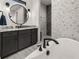 Elegant bathroom featuring a modern soaking tub, a dark wood vanity and patterned tile at 12581 Eisenhower Dr, Port Charlotte, FL 33953