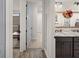 Hallway view of a bathroom featuring a decorative mirror and marble countertop sink at 12581 Eisenhower Dr, Port Charlotte, FL 33953
