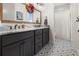 Bathroom features a decorative mirror, double sinks, and patterned tile floor at 12581 Eisenhower Dr, Port Charlotte, FL 33953