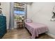 Bright bedroom with hardwood floors, large window, and a cozy bed at 12581 Eisenhower Dr, Port Charlotte, FL 33953