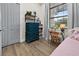 Bedroom with hardwood floors, blue dresser, grey doors and a large window at 12581 Eisenhower Dr, Port Charlotte, FL 33953