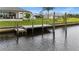 A well-maintained wooden dock on the canal with steps down to the water and lush green landscaping at 12581 Eisenhower Dr, Port Charlotte, FL 33953