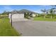 Beautiful home featuring three-car garage, large driveway, basketball hoop, and manicured lawn at 12581 Eisenhower Dr, Port Charlotte, FL 33953