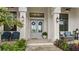 Inviting front entrance featuring double doors with wreaths, stylish outdoor seating, and manicured plants at 12581 Eisenhower Dr, Port Charlotte, FL 33953