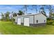 A large gray and silver metal garage with two bay doors and simple architecture, suitable for storage or a workshop at 12581 Eisenhower Dr, Port Charlotte, FL 33953