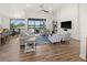 Bright, open-concept living room with hardwood floors, comfortable seating, and a view of the backyard and pool at 12581 Eisenhower Dr, Port Charlotte, FL 33953