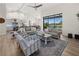 Open-concept living area featuring hardwood floors, comfortable sofas, and a seamless transition to the kitchen at 12581 Eisenhower Dr, Port Charlotte, FL 33953