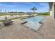 Beautiful pool and travertine tile deck overlooking water and lush tropical landscaping at 12581 Eisenhower Dr, Port Charlotte, FL 33953