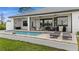 A stunning backyard pool with a covered patio, outdoor seating, and a well-manicured lawn, perfect for relaxing or entertaining at 12581 Eisenhower Dr, Port Charlotte, FL 33953