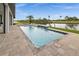 Sparkling pool with a stone patio overlooking a scenic canal and mature palm trees at 12581 Eisenhower Dr, Port Charlotte, FL 33953
