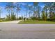 View of property featuring a long, paved driveway leading to a house surrounded by trees and vegetation at 12581 Eisenhower Dr, Port Charlotte, FL 33953