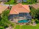 Aerial view of a private pool and lanai surrounded by mature tropical landscaping at 13136 N Marsh Dr, Port Charlotte, FL 33953