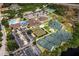 An aerial view showcases a community center with a pool, tennis courts, and lush landscaping at 13136 N Marsh Dr, Port Charlotte, FL 33953