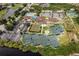 An aerial view showcases community amenities, including tennis courts, a pool, and a clubhouse near a lake at 13136 N Marsh Dr, Port Charlotte, FL 33953