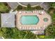 Aerial shot of a community pool with ample lounge chairs, tables, and lush landscaping at 13136 N Marsh Dr, Port Charlotte, FL 33953