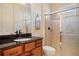 A well-appointed bathroom featuring a vanity with black granite counters and a glass-enclosed shower at 13136 N Marsh Dr, Port Charlotte, FL 33953