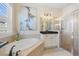 This spacious bathroom features a soaking tub, glass-enclosed shower, and a large format art piece at 13136 N Marsh Dr, Port Charlotte, FL 33953
