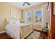 Cozy bedroom with a plush bed, wood floors, and a view of the landscaped yard through shuttered windows at 13136 N Marsh Dr, Port Charlotte, FL 33953