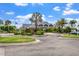 Scenic view of the Clubhouse entrance, showcasing lush landscaping, a roundabout, and ample parking with lush curb appeal at 13136 N Marsh Dr, Port Charlotte, FL 33953