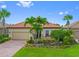 Beautiful single-story home featuring a paver driveway and lush tropical landscaping at 13136 N Marsh Dr, Port Charlotte, FL 33953