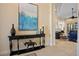 Tastefully decorated foyer showcasing a dark console table, artwork, and a glimpse into the inviting living spaces at 13136 N Marsh Dr, Port Charlotte, FL 33953