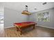 A game room with a classic pool table provides a leisure space with a pendant light and wood-look flooring at 13136 N Marsh Dr, Port Charlotte, FL 33953
