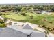 Aerial view of the community golf course, featuring lush greens, landscaping, and a tranquil water feature at 13136 N Marsh Dr, Port Charlotte, FL 33953