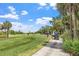 Golfers on a lush green golf course under a blue sky with scattered white clouds at 13136 N Marsh Dr, Port Charlotte, FL 33953