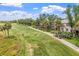 A scenic view of golfers on the golf course, featuring manicured greens and lush landscaping at 13136 N Marsh Dr, Port Charlotte, FL 33953