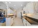 Open kitchen with granite counters, white cabinetry, stainless appliances, and tile flooring at 13136 N Marsh Dr, Port Charlotte, FL 33953