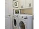 Well-equipped laundry room with modern front-load washer and dryer, and stylish cabinetry at 13136 N Marsh Dr, Port Charlotte, FL 33953