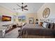 Comfortable main bedroom with king bed, sitting area, ceiling fan, and view of backyard at 13136 N Marsh Dr, Port Charlotte, FL 33953