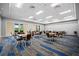 Bright meeting room features tables and chairs, doors to the outside, and modern carpet at 13136 N Marsh Dr, Port Charlotte, FL 33953