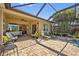 A covered patio featuring brick flooring, elegant seating, and a ceiling fan for comfortable outdoor living at 13136 N Marsh Dr, Port Charlotte, FL 33953