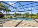 Enjoy outdoor living with this screened-in pool, offering a tranquil view of the lush backyard and serene lake at 13136 N Marsh Dr, Port Charlotte, FL 33953